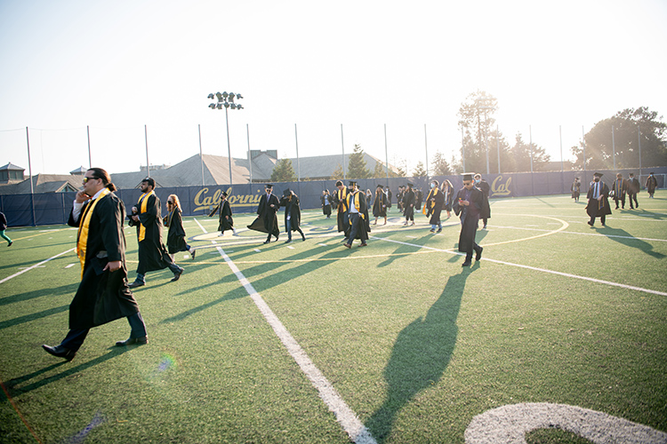 Grads walk across Witter Rugby Field on their way to the Class of 2020 In-Person Commencement at the Greek Theatre