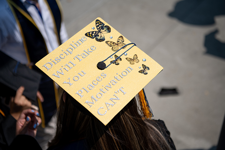 A mortarboard on a graduate's head says 