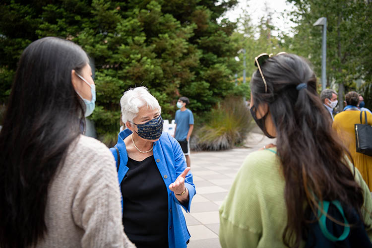 christ, in a mask, talks to students