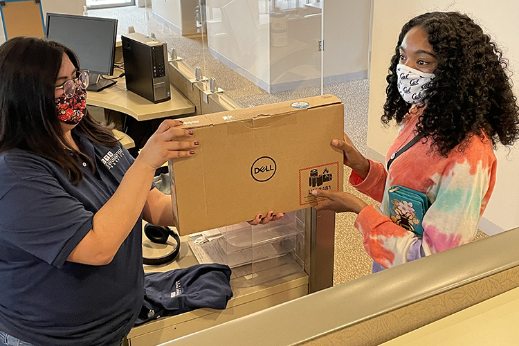 A student picks up a free loaner laptop from the Student Technology Equity Program.