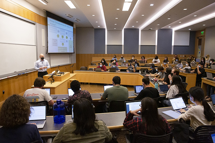 Professor Robert Bartlett's Securities Regulation class, with 80 students, meets in a large lecture room. Everyone is in masks, both students and professor.