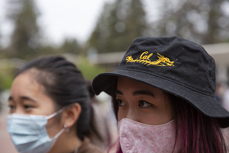 A Cal Dragonboat club member's hat is blue with a gold dragon on it.