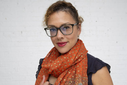 Tina Sacks, social protection teacher looks at the camera with an orange scarf