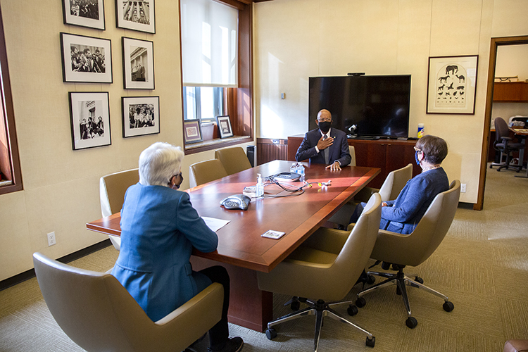 drake talks with christ and koshland in an airy, well-lit conference room with a wood table