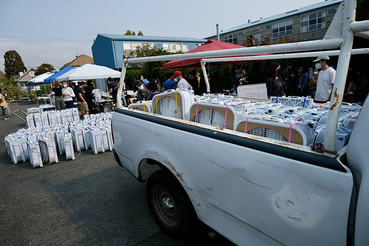 A white pick-up truck is loaded with DIY air purifiers that will be delivered to people in need.
