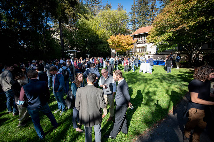 a crowd gathers on faculty glade on a sunny day