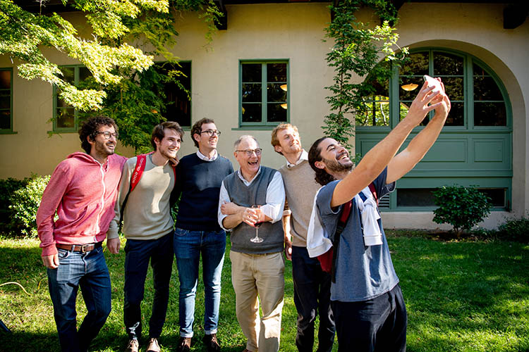 card poses for a selfie with a group of young people