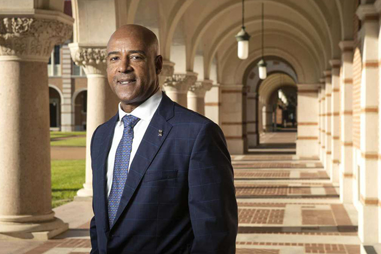 Reginald DesRoches stands in a corridor wearing a suit