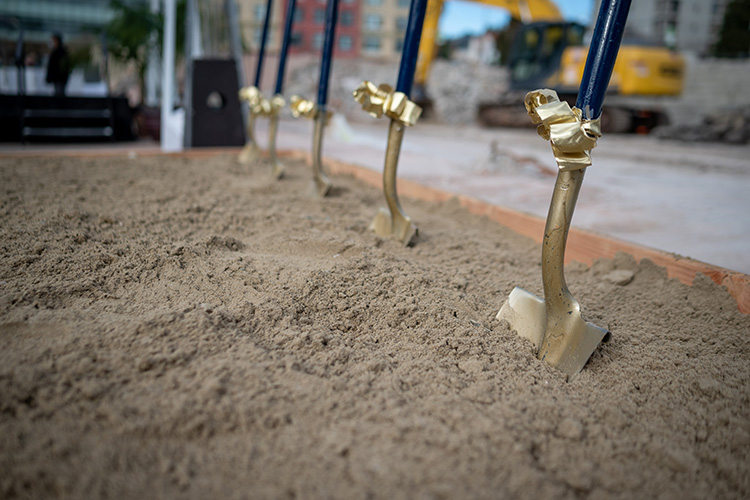 Golden shovels dug into the soil at the Anchor House construction site.