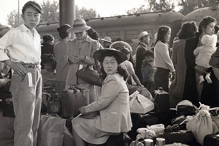 families of Japanese ancestry wait with their belongings