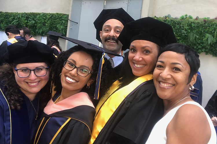 AMani Allen at a student graduation posing with a group of her students.