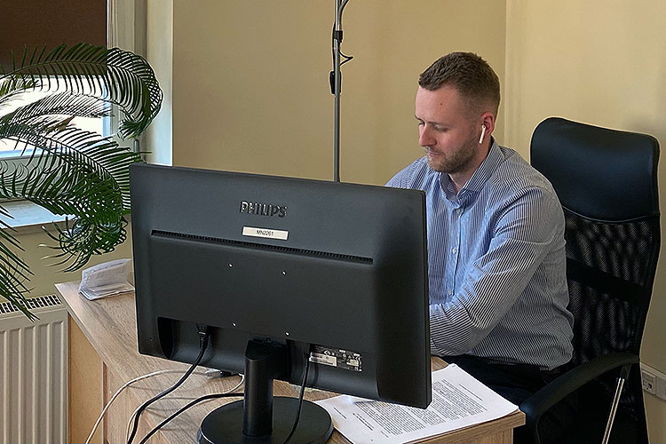 Ukrainian attorney Arsen Kulyk, a student in Berkeley Law's Master of Laws program, working at a desk in his makeshift office in Poland