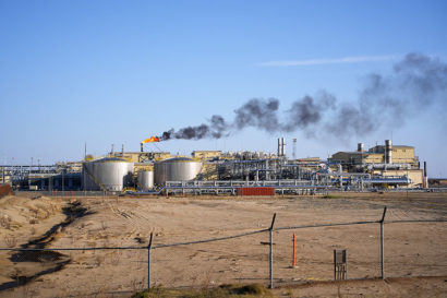 A photo of a petrochemical plant, billowing smoke from a smokestack