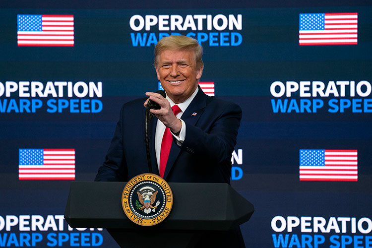 In 2020, then-President Donald Trump speaks before an Operation Warp Speed backdrop at an event to promote rapid development of COVID-10 vaccines