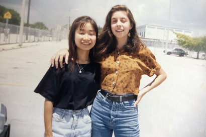 two high school students stand next to each other smiling