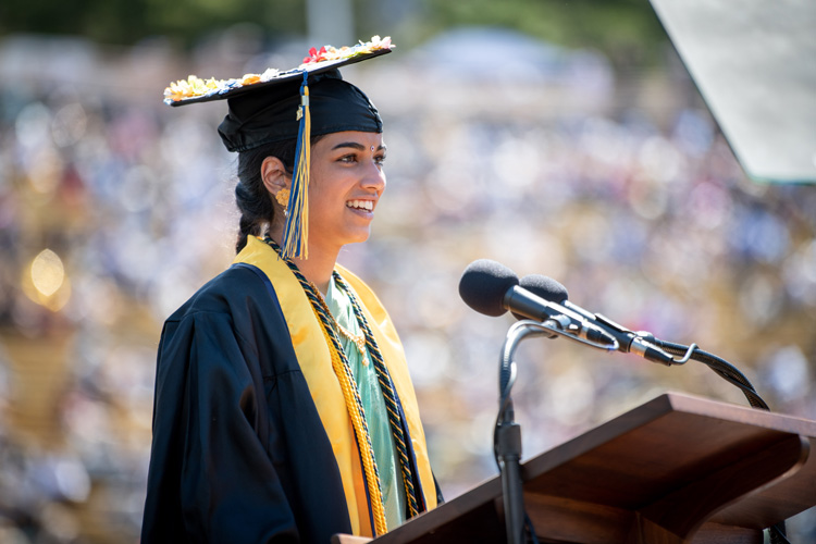 top graduate Anjika Pai speaks at a podium