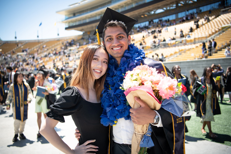 a man and woman pose after graduation