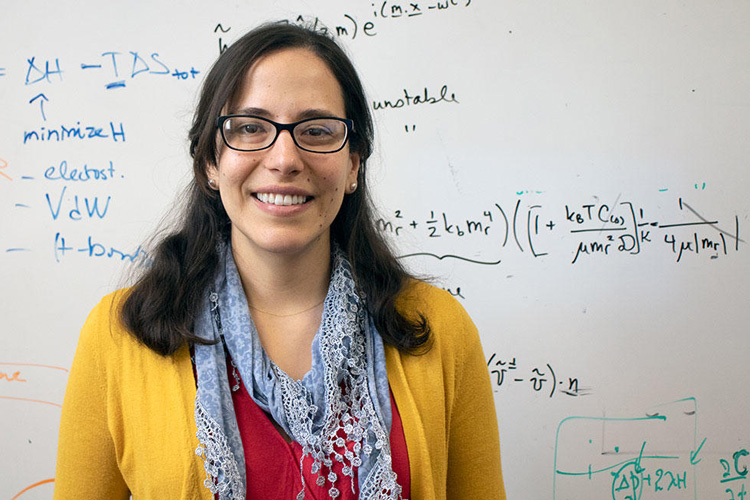 Landry standing in front of a white board with equations