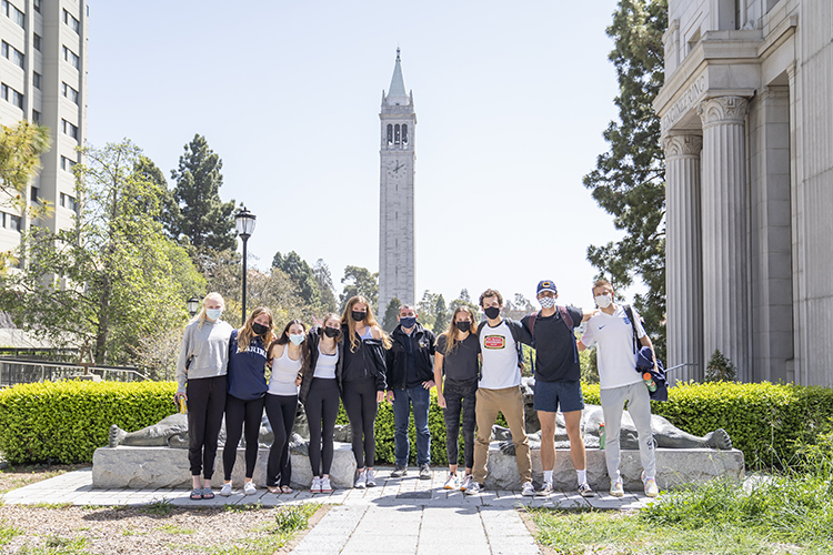 Professor Oliver O'Reilly and nine students from his freshman seminar called Bears in Boats: A History of Women and Men's Rowing at the University of California, Berkeley, pose in masks on campus, with the Campanile in the background.