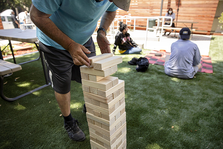A client plays jenga on the law at the center.