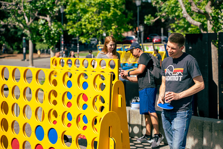 Carnival goers playing the Connect Four game.