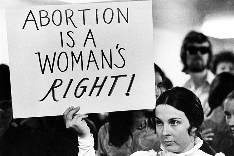 a person holds up a sign that reads 