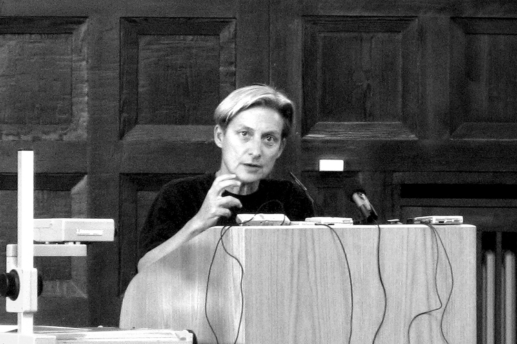 In a black and white photo, Judith Butler delivers a lecture in 2007 at the University of Hamburg in Germany. (Photo by Jreberlein, Wikimedia Commons)