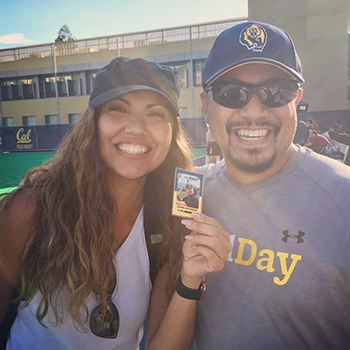 Glenn DeGuzman, the softball commissioner for the Student Affairs Summer Softball League, admires a baseball card with his photo on it that was made by a Residential Life intern in summer 2018.