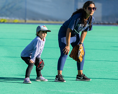 Bahar Navab, assistant vice chancellor and chief of staff for student affairs, and her young son, Kasra, bend their knees and get their mitts ready to catch the ball at a Student Affairs Summer Softball League game.