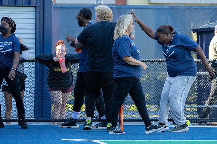 Players high-five each other at a Student Affairs Summer Softball League game.