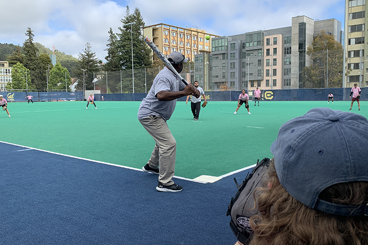 A batter takes his spot at home plate and awaits a pitch at a Student Affairs Summer Softball League game.