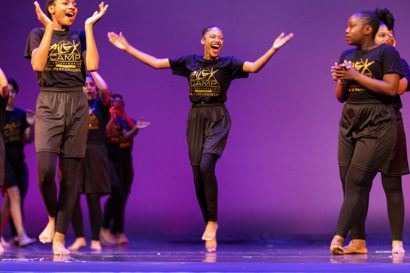 young dancers smile and dance on stage