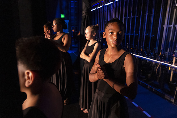 young dancers stand backstage