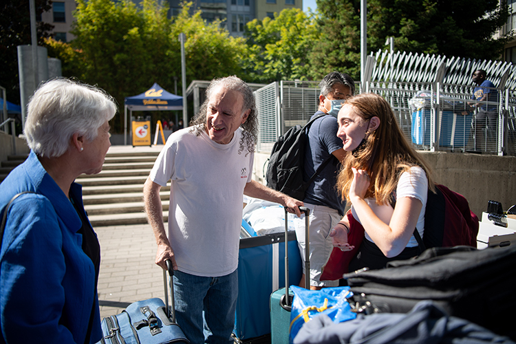 Chancellor Carol Christ greets a student and her father outside of a residence hall during Move-in days 2022.