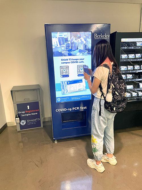 A student tries out the new vending machine at the MLK Jr. Student Union that provides students, staff and faculty with free COVID-19 PCR tests.