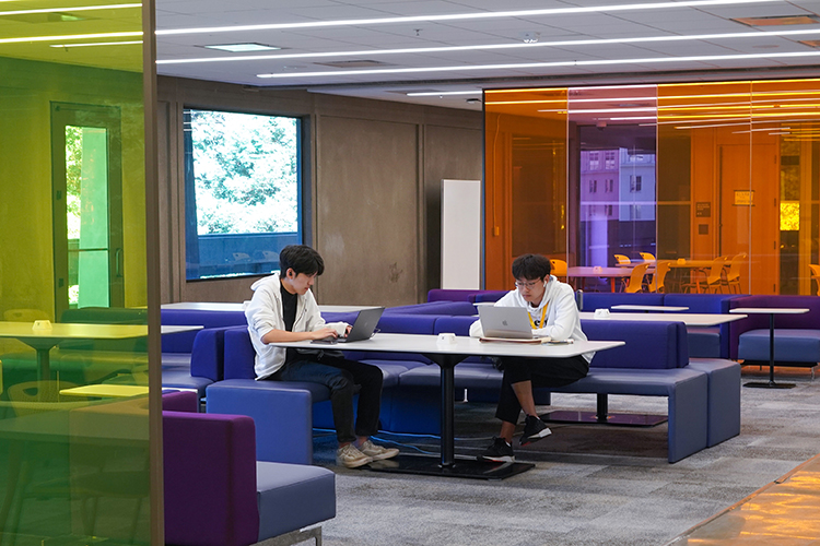 Two students study at a table at Moffitt Library.