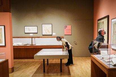 people look at display cases in a library exhibit