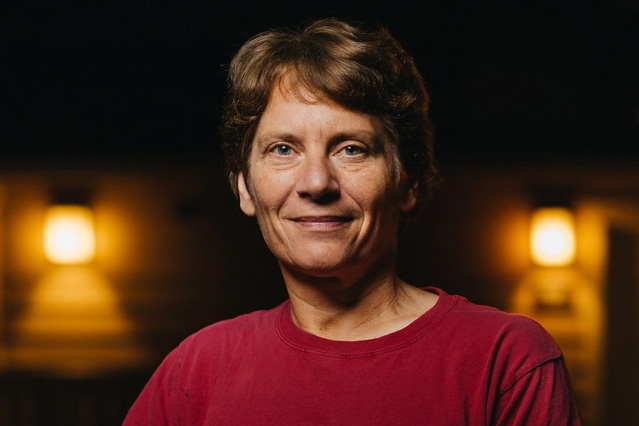 Carolyn Bertozzi portrait, taken at night with lights in the background