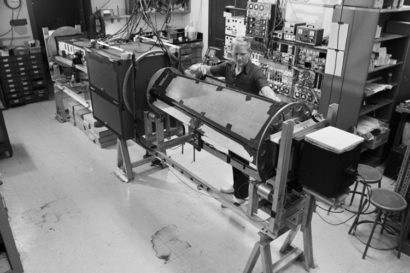 black and white photo of John Clauser with experimental apparatus