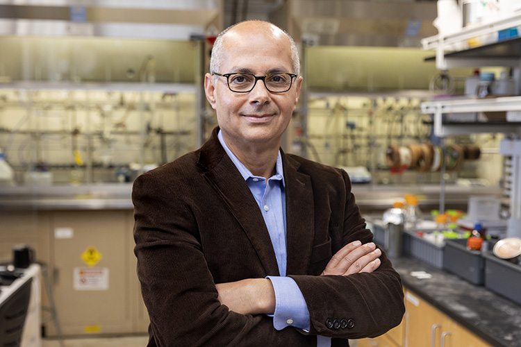 Chemist Omar Yaghi, with arms crossed, in his lab