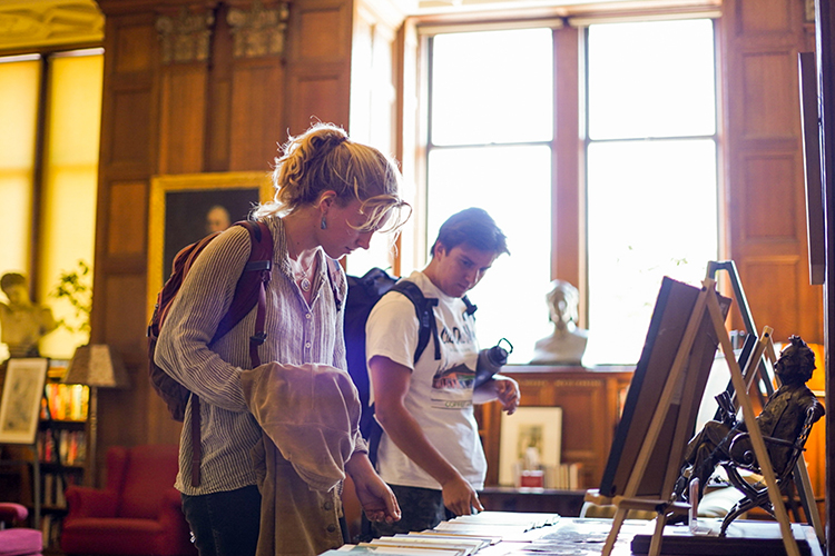 two people look at art on a table