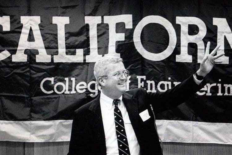 David Hodges stands in front of a sign saying 