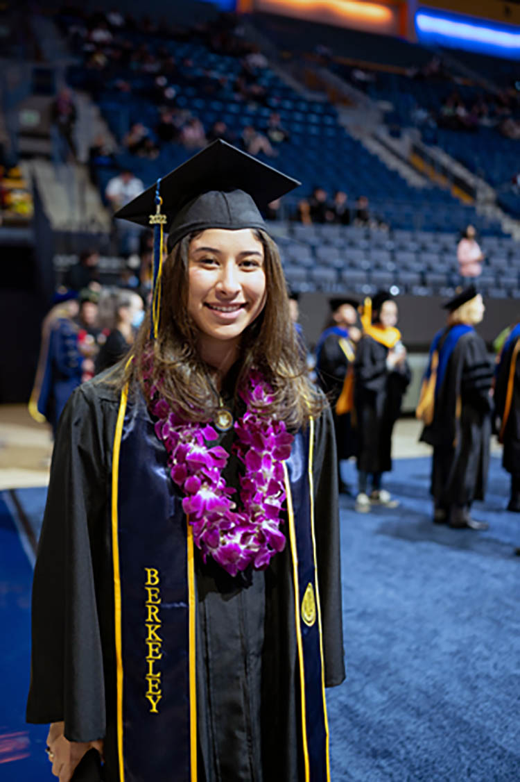 a graduate in cap and gown and a flower lei necklace