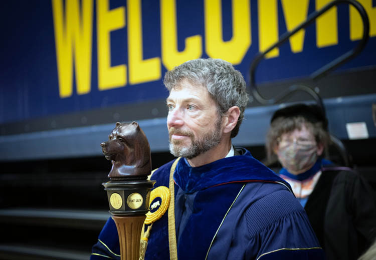 hermalin holds a wooden bear staff