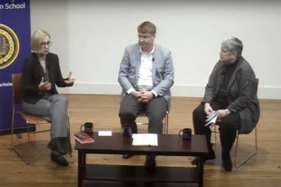 three people sitting on a stage talking