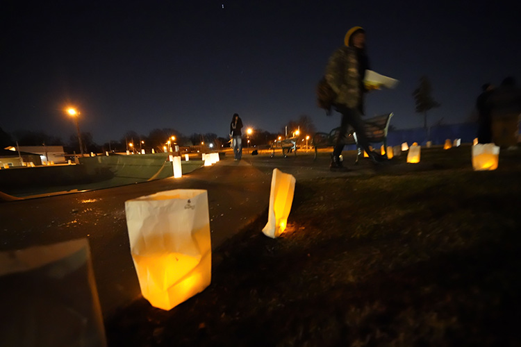 candles in bags glow yellow as a person walks by