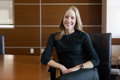 A photo of Brandie Nonnecke sitting at a conference room table