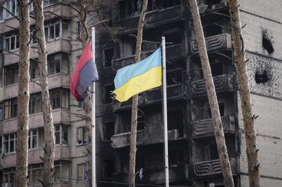 Two flags near a burned building