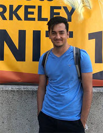 Alp Eren Özdarendeli, a Berkeley sophomore from Turkey, stands in front of UC Berkeley signage at a residence hall.