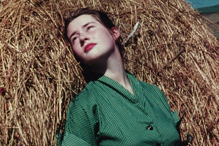 A woman leans against a stack of hay in an image from a short film being shown at the BAMPFA's Out of the Vault film series.